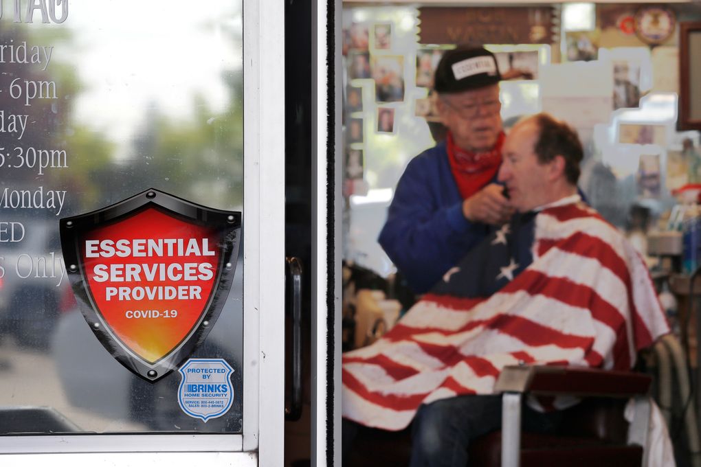 Barber Bob Martin, who’s been cutting hair at Stag Barber & Styling in Snohomish for 51 years, is welcoming back customers in defiance of Gov. Jay Inslee’s extended stay-home order. (Elaine Thompson / The Associated Press)
