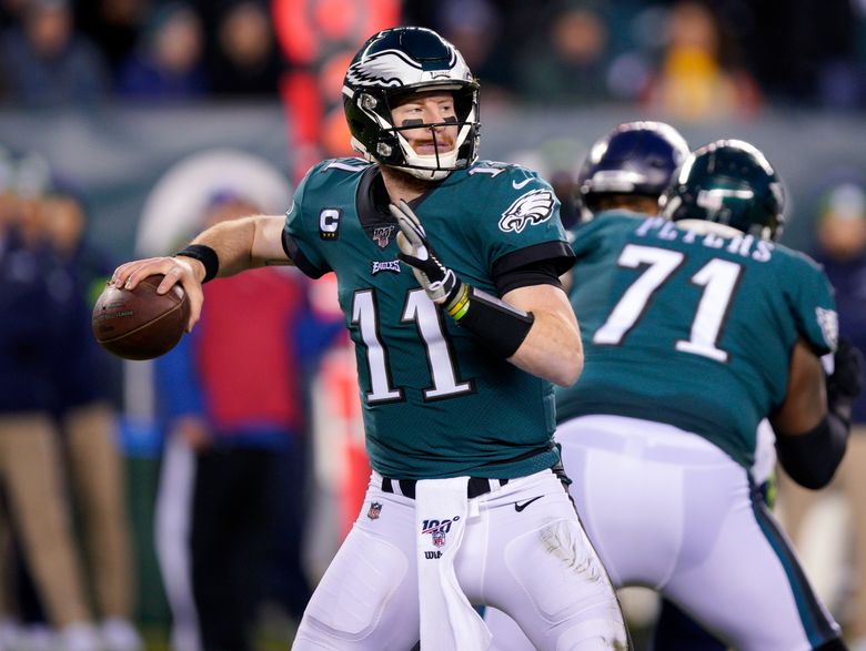 Eagles injured quarterback Carson Wentz holds up the Lombardi Trophy