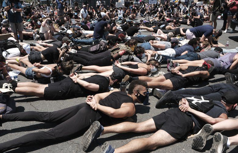 LGBT community members join Black Lives Matter demonstrators lie face down depicting George Floyd during his detention by police, blocking an intersection in protest over Floyd’s death, in West Hollywood, Calif. on Wednesday, June 3, 2020.  Floyd, an African American, died on May 25 after a white Minneapolis police officer pressed a knee into his neck for several minutes even after he stopped moving and pleading for air.(AP Photo/Richard Vogel) CARV309 CARV309
