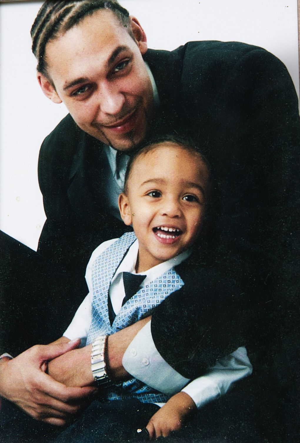 Leonard Thomas snuggles his son, Elijah, in a family photo. Thomas was shot by a police sniper in 2013 while he stood on his porch and held Elijah, who was then 4. (Courtesy of the Thomas family)