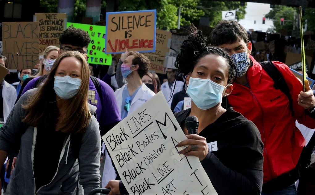 Microphone in hand, Hazzauna Underwood leads protesters in chants as they march from Harborview Medical Center to City Hall plaza on June 6. (Alan Berner / The Seattle Times)