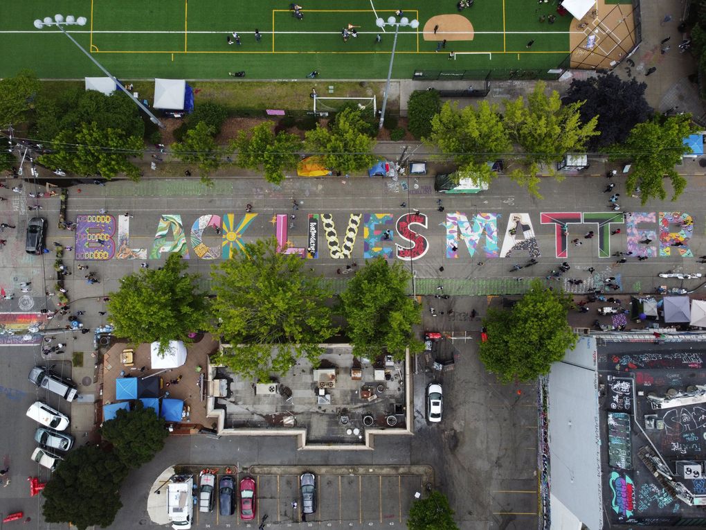 An aerial view of the finished Black Lives Matter mural on East Pine Street in Seattle on Sunday . Artists completed the mural Thursday night. The artwork is in the CHOP, after being renamed from the CHAZ. (Ken Lambert / The Seattle Times)