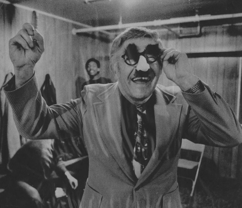 UW men’s basketball coach Marv Harshman wears Groucho Marx glasses in the locker room after a 1976 victory over the Oregon Ducks. Harshman and five Husky players wore Groucho Marx glasses to mock the Oregon players during pregame warmups. (AP file)