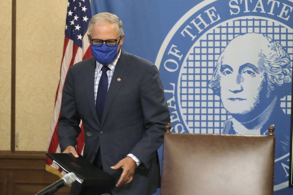 Washington Gov. Jay Inslee wears a face mask as he arrives to speak at a news conference at the Capitol in Olympia on Tuesday. Inslee announced that Washington state will require people to wear facial coverings in most indoor and outdoor public settings, under a statewide public health order in response to ongoing COVID-19 related health concerns. (Ted S. Warren / The Associated Press)