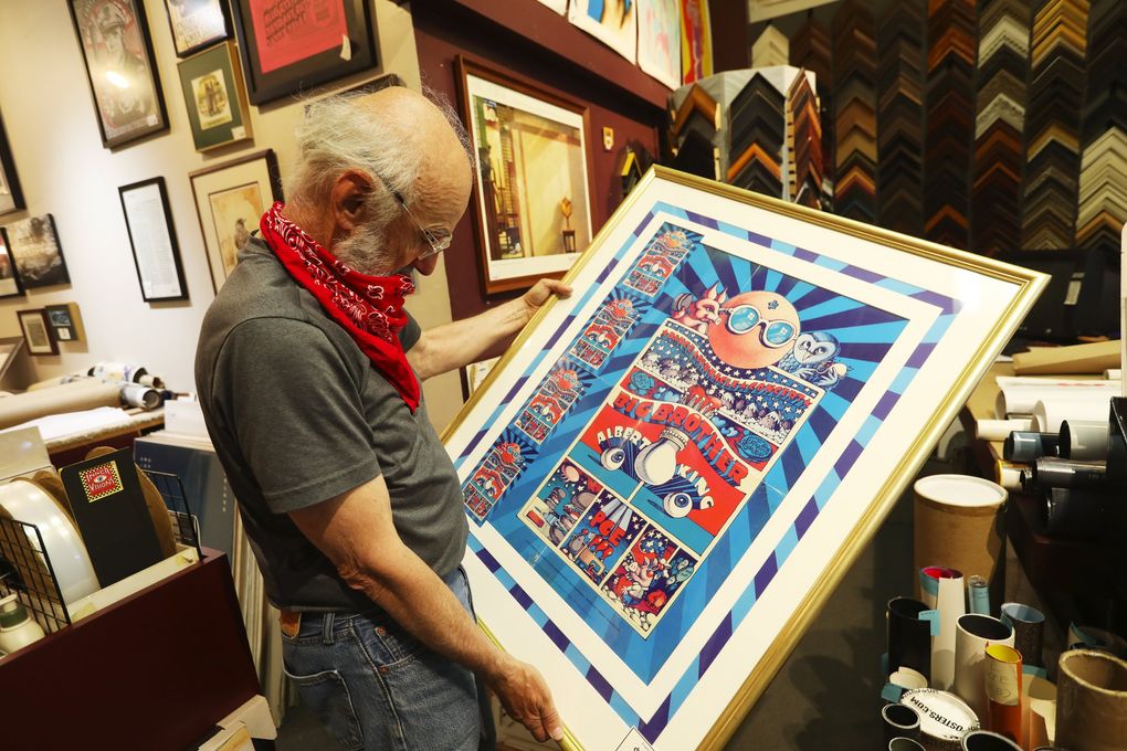 Innervisions owner Steve Delph holds an original 1968 poster for a Big Brother and the Holding Company/Albert King concert. (Ken Lambert / The Seattle Times)