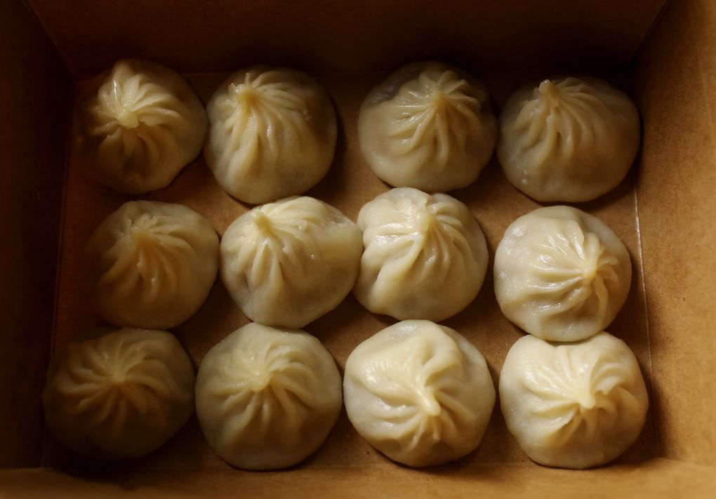 Soup dumplings are seen in a carryout box at XCJ (Xiao Chi Jie) Monday, May 18, 2020 in Bellevue. (Ken Lambert / The Seattle Times)