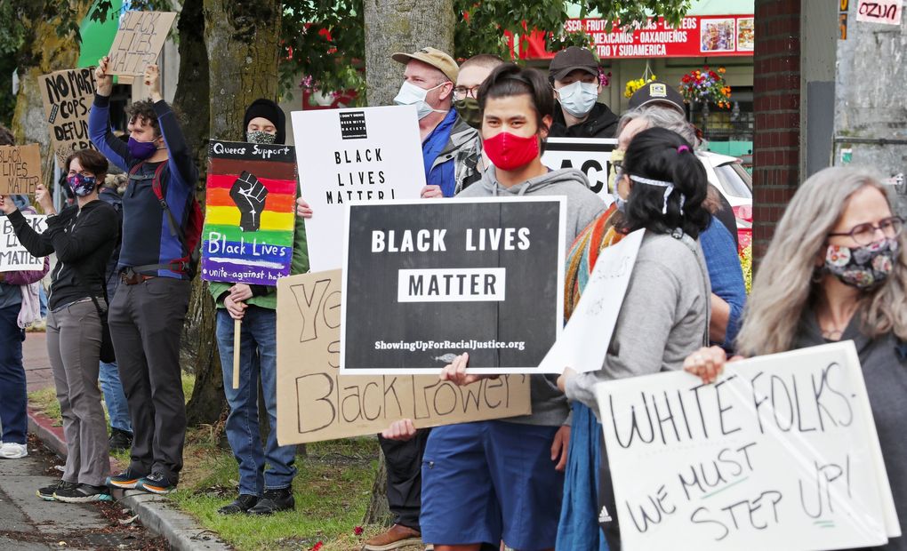 Protesters attend a neighborhood vigil honoring the life of George Floyd and others, Monday, June 15, 2020 in Seattle’s Columbia City. (Ken Lambert / The Seattle Times)