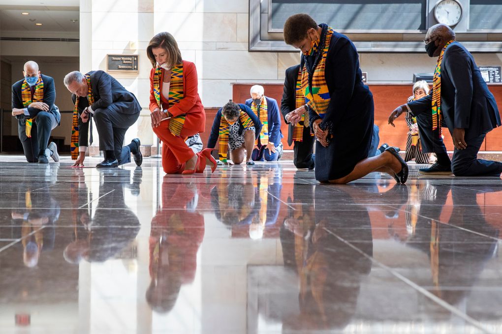 House Speaker Nancy Pelosi of Calif., center, and other members of Congress gather at the Emancipation Hall, kneel and observe a moment of silence to honor George Floyd, and victims of racial injustice, Monday, June 8, 2020, in Washington. (AP Photo/Manuel Balce Ceneta)