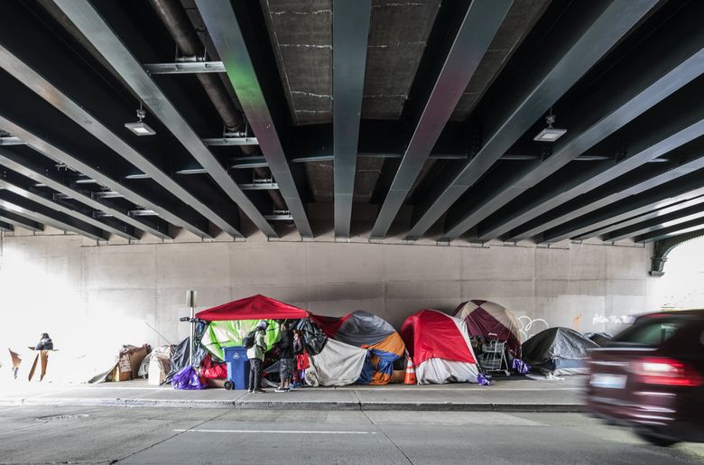 Homeless camps previously moved by the city are more of a fixture in and around downtown Seattle in this period of shutdown from the virus.  This camp on April 29 was located on Fourth Ave. under the Yesler Way overpass in downtown Seattle. (Steve Ringman / The Seattle Times)