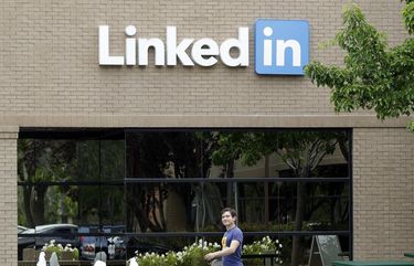 FILE – In this May 8, 2014, file photo, a man walks past the LinkedIn headquarters in Mountain View, Calif. (AP Photo/Marcio Jose Sanchez, File) PAPM105