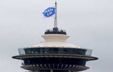 Early Friday morning, standing at the top of the Space Needle, King County Executive Dow Constantine hoists a flag that reads “Mask Up.” Wearing a mask or face covering, shown to be effective in slowing the spread of COVID-19, is also a rule statewide.

July 10, 2020