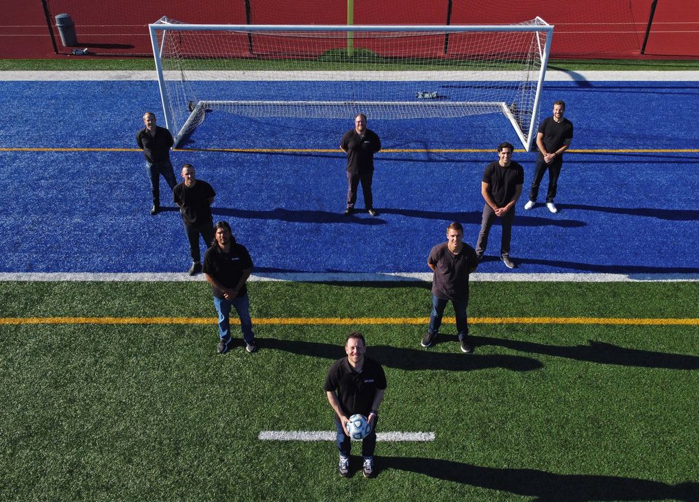 Teammates and friends of University of Washington soccer player Daniel Phelps, who died in his sleep of sudden cardiac arrest in 2015, stand on the Shoreline Stadium soccer field, Monday, July 13, 2020. Adam Lang, in front at the point; and Taylor Hoss, next row, left; helped organize, with a few of Phelps’ teammates, an annual charity golf tournament – the DP Open – to honor their teammate and raise awareness for sudden cardiac arrest. 214471 (Ken Lambert / The Seattle Times)