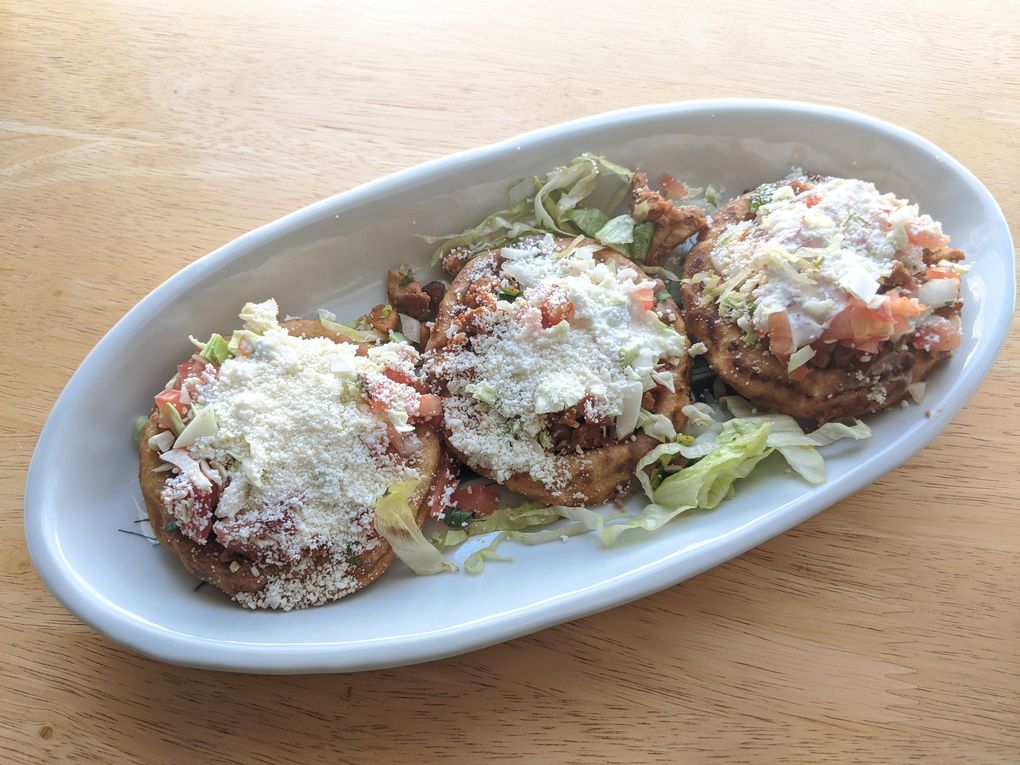 Don’t miss the sopitos — crispy, thick tortillas that cradle beans, chicken (or your choice of meat), cabbage, onions, cotija cheese and crema — at Taqueria el Sabor in Shoreline. (Jackie Varriano / The Seattle Times)