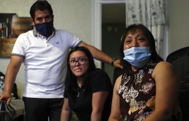 Magnolia Ortega, right, sits with her husband, Arturo Morales, and their daughter Marlene at their home in Staten Island, New York, last month. Ortega is considering returning with her husband and daughter to her hometown of San Jeronimo Xayacatlan, Mexico, but says there’s no work there either and that would mean one less family member sending back one less monthly check. (AP Photo/John Minchillo)