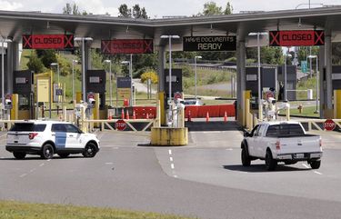 In this photo taken Sunday, May 17, 2020, a truck from Canada heads to the single open lane heading into the U.S. at the Peace Arch border crossing in Blaine, Wash. Canada and the U.S. have agreed to extend their agreement to keep the border closed to non-essential travel to June 21 during the coronavirus pandemic. The restrictions were announced on March 18, were extended in April and now extended by another 30 days. (AP Photo/Elaine Thompson)