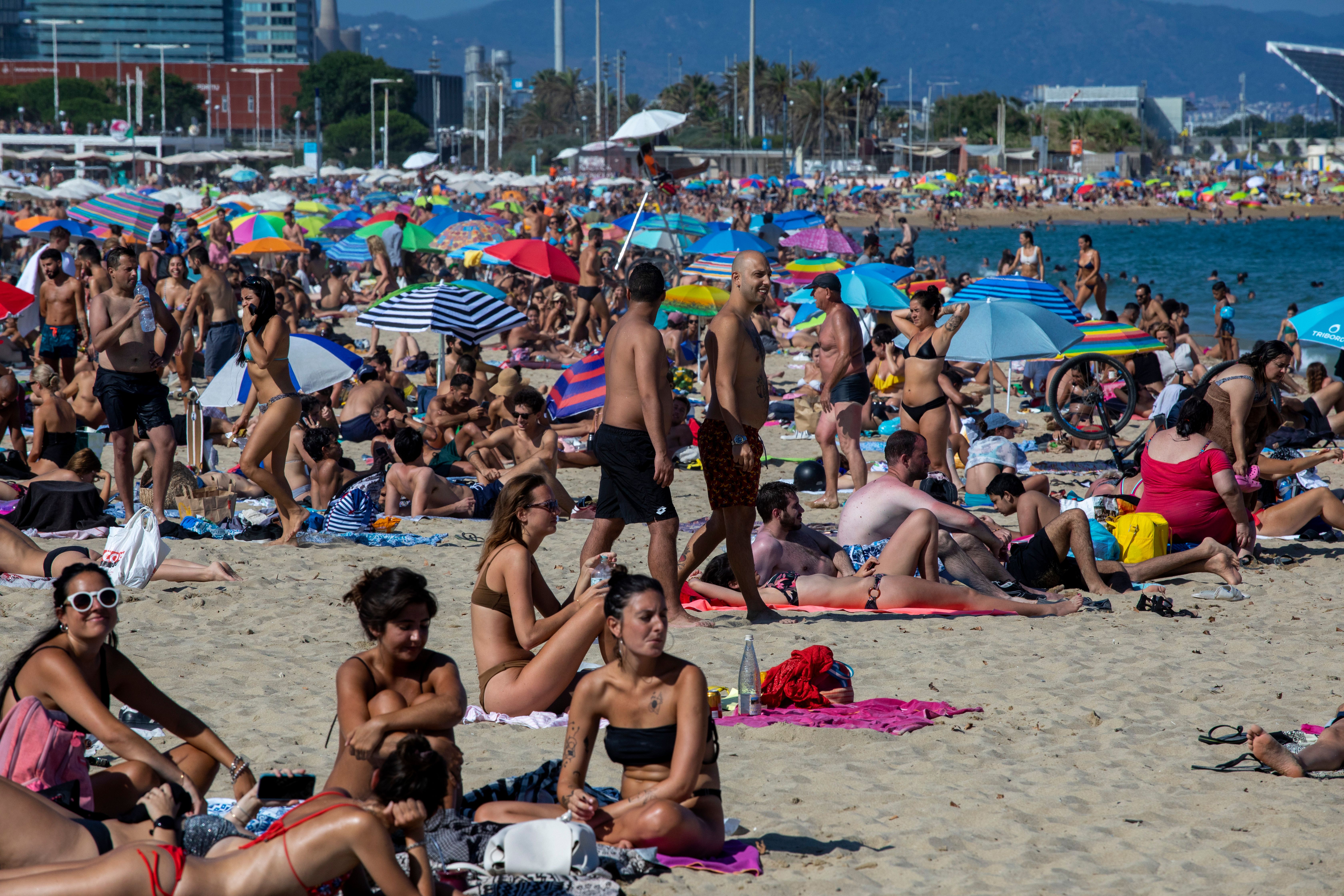 Police close down packed Barcelona beach amid virus spike The