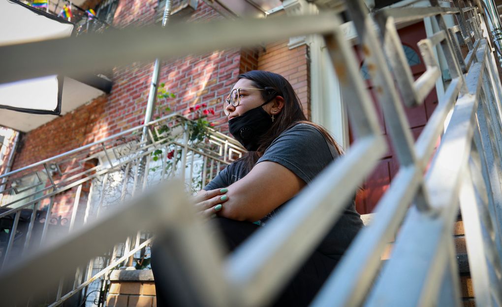 Natalia Afonso, 27, an international student from Brazil at Brooklyn College, sits on a stoop outside her home during an interview, Thursday, July 9, 2020, in New York. Afonso, who is studying teaching education and finished her first semester this spring, said she has lived in the U.S. for 7 years and “I don’t see myself moving back to Brazil at this point. (AP Photo/Bebeto Matthews)