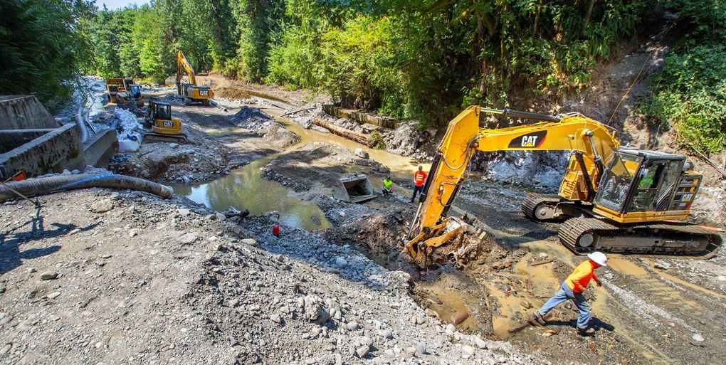 While water from the Pilchuck River is diverted through the old fish ladder at left, crews from The Tulalip Tribes work to remove the Pilchuck Dam, built in 1912, that once supplied water to the town of Snohomish. Removing the dam near Granite Falls will open 37 miles of spawning habitat for many species of fish. (Mike Siegel / The Seattle Times)