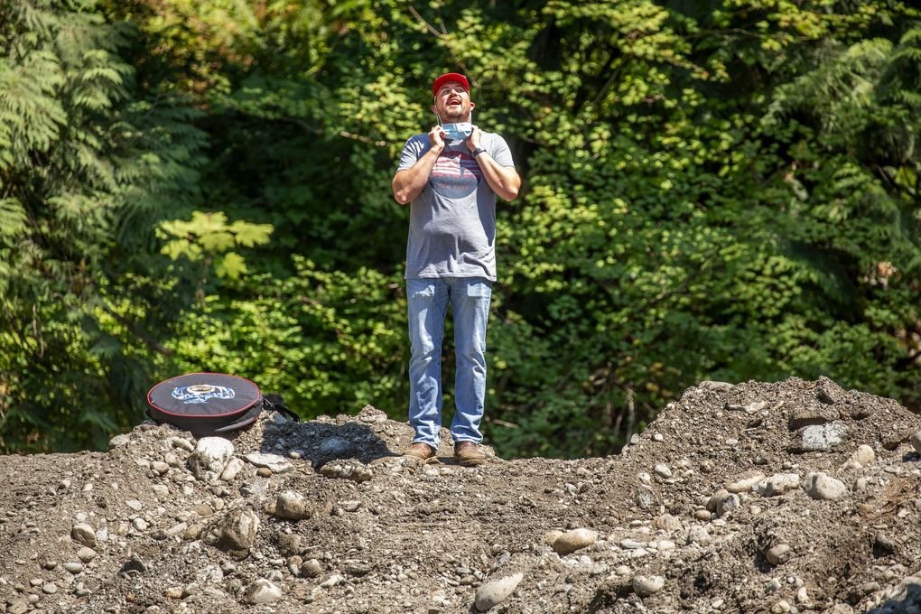 “From here, it only gets better,” said Ryan Miller, environmental liaison with The Tulalip Tribes, shown here as he takes off his face mask while watching the old dam come down. (Mike Siegel / The Seattle Times)