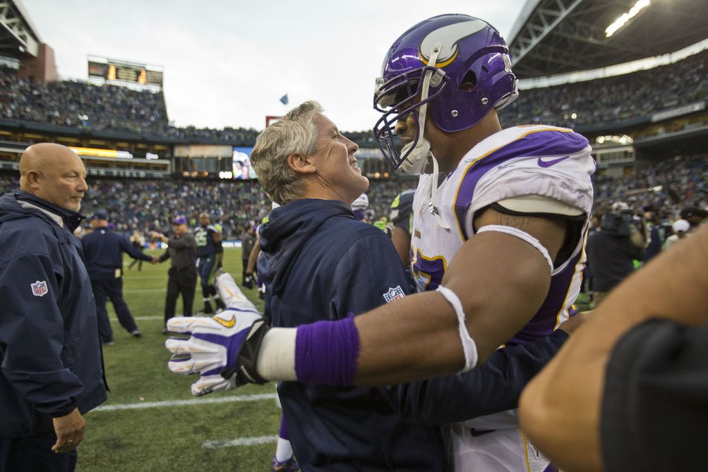 Coach Pete Carroll receives a hug from Minnesota defensive end Everson Griffen following a game in 2012. (Dean Rutz / The Seattle Times, file)