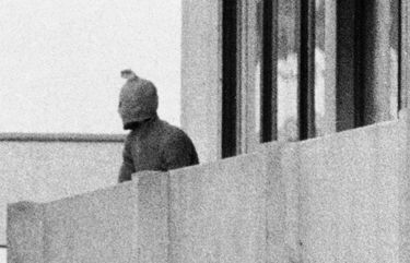 FILE – On Sept. 5, 1972, a Palestinian commando group seizes the Israeli Olympic team quarters at the Olympic Village in Munich, Germany. A member of the commando group is seen here as he appears with a hood over his face on the balcony of the building, where they hold several Israeli athletes hostage. (AP Photo/Kur Stumpf, File) NYDD303