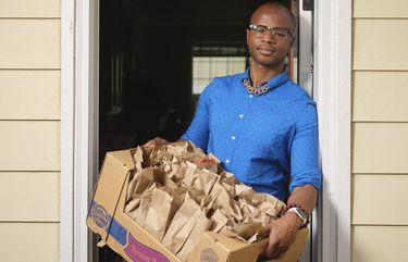 Cameron Whitten, who founded the Black Resilience Fund out of his home in Portland, Ore., helps load meals to feed the city’s homeless. MUST CREDIT: Photo by Leah Nash for The Washington Post.
