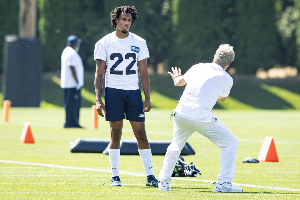 Seahawks coach Pete Carroll does a little show and tell with new cornerback Quinton Dunbar at the Virginia Mason Athletic Center in Renton on Sunday. (Bettina Hansen / The Seattle Times)