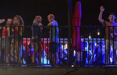 Patrons congregate on the rooftop bar at the Bear Trap, a bar on The Strip, a neighborhood near the University of Alabama campus in Tuscaloosa.  (AP Photo/Vasha Hunt) 