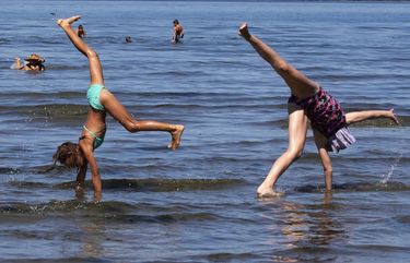 Friends (l-r) Diana Volynets, 7, of Algona; Kathrin Oleksiyenko, 8, of Federal Way; and Evelyn Gapon, 12, of Lake Tapps show their talents at Dash Point State Park in Federal Way Monday, August 17, 2020.  They were there with family and friends.  Temperatures are expected to reach 90 degrees Monday, but the rest of the week will be a lot cooler with temps. in the high or low 70’s. 214806