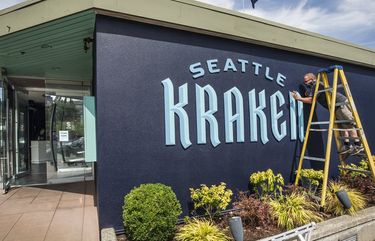 Wed. August 19, 2020   Kelly Bridgeman from Sign Pros finishes installing the Seattle Kraken sign on the official team store in Chandler’s Cove.   214838