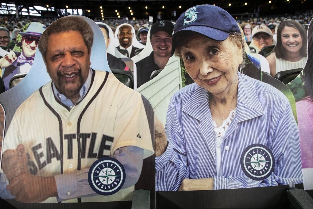 Atsuko Lile, aka Mama San, is an 87-year-old fan undergoing chemotherapy, and has a cutout next to Sonics legend Fred Brown. (Dean Rutz / The Seattle Times)