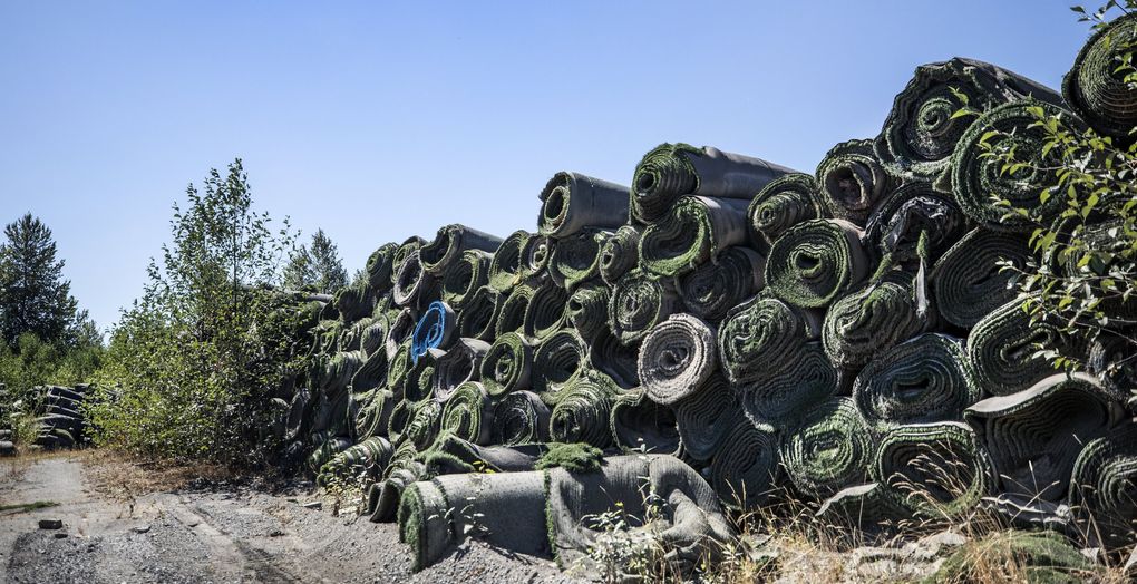 Piles of old artificial turf are stored nearby the Electron Dam on the Puyallup River. (Steve Ringman / The Seattle Times)