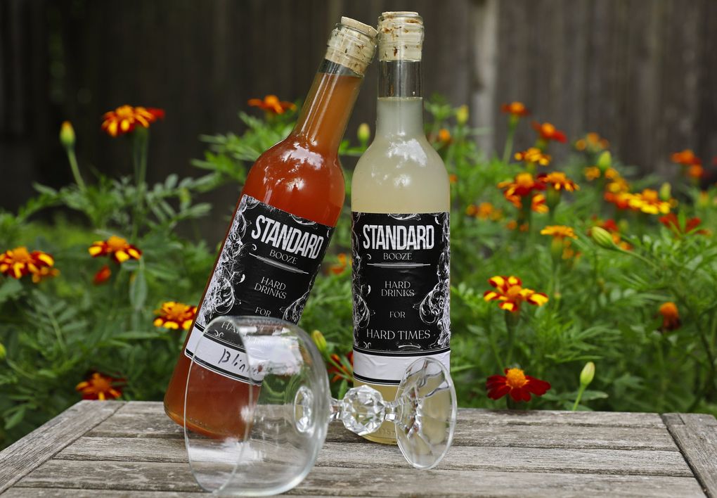 Two cocktails to go from Standard Brewing: the Blinker, left, with bourbon, raspberry syrup and grapefruit; and the Hemingway Daiquiri, with rum, Maraschino, lime and grapefruit. (Ken Lambert / The Seattle Times)