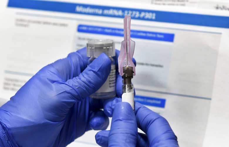 A nurse prepares a shot as a study of a possible COVID-19 vaccine developed by the National Institutes of Health and Moderna in Binghamton, N.Y. (Hans Pennink / The Associated Press, file)