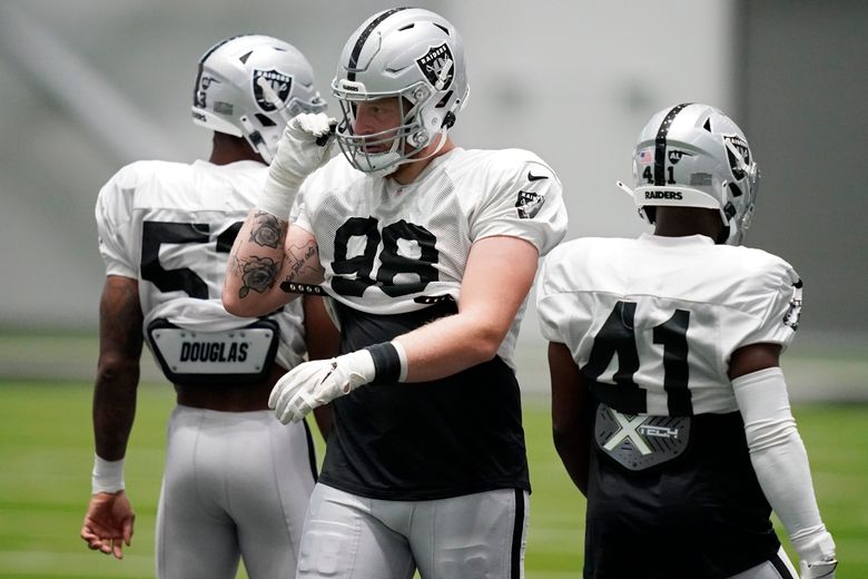 Raiders defensive end Maxx Crosby (98) talks with teammates during