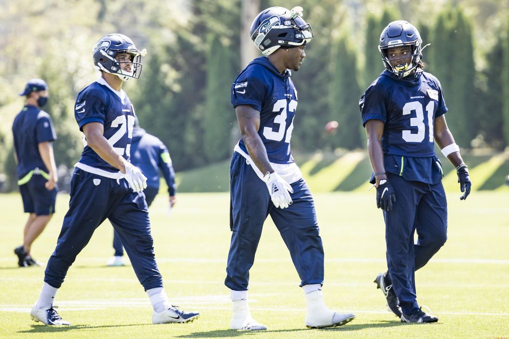 Running backs from right, DeeJay Dallas, Chris Carson and Travis Homer talk as the Seattle Seahawks hold training camp at the VMAC in Renton. (Bettina Hansen / The Seattle Times)