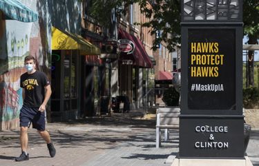 **EMBARGO: No electronic distribution, Web posting or street sales before SUNDAY 3:01 A.M. ET SEPT. 6, 2020. No exceptions for any reasons. EMBARGO set by source.**A pedestrian in downtown Iowa City, Iowa, Sept. 3, 2020. Iowa City is a full-blown pandemic hot spot – one of about 100 college communities around the country where infections have spiked in recent weeks as students have returned for the fall semester. (Kathryn Gamle/The New York Times) XNYT58