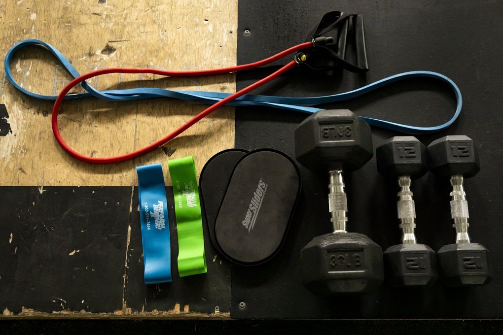 Simple equipment like resistance bands, dumbbells and sliders can elevate your home workout routine. (Bettina Hansen / The Seattle Times)