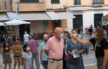 FILE — Checking temperatures outside a cinema in Málaga, Spain, on Aug. 30, 2020. New infections have soared in recent weeks in the country. (Samuel Aranda/The New York Times) XNYT61 XNYT61