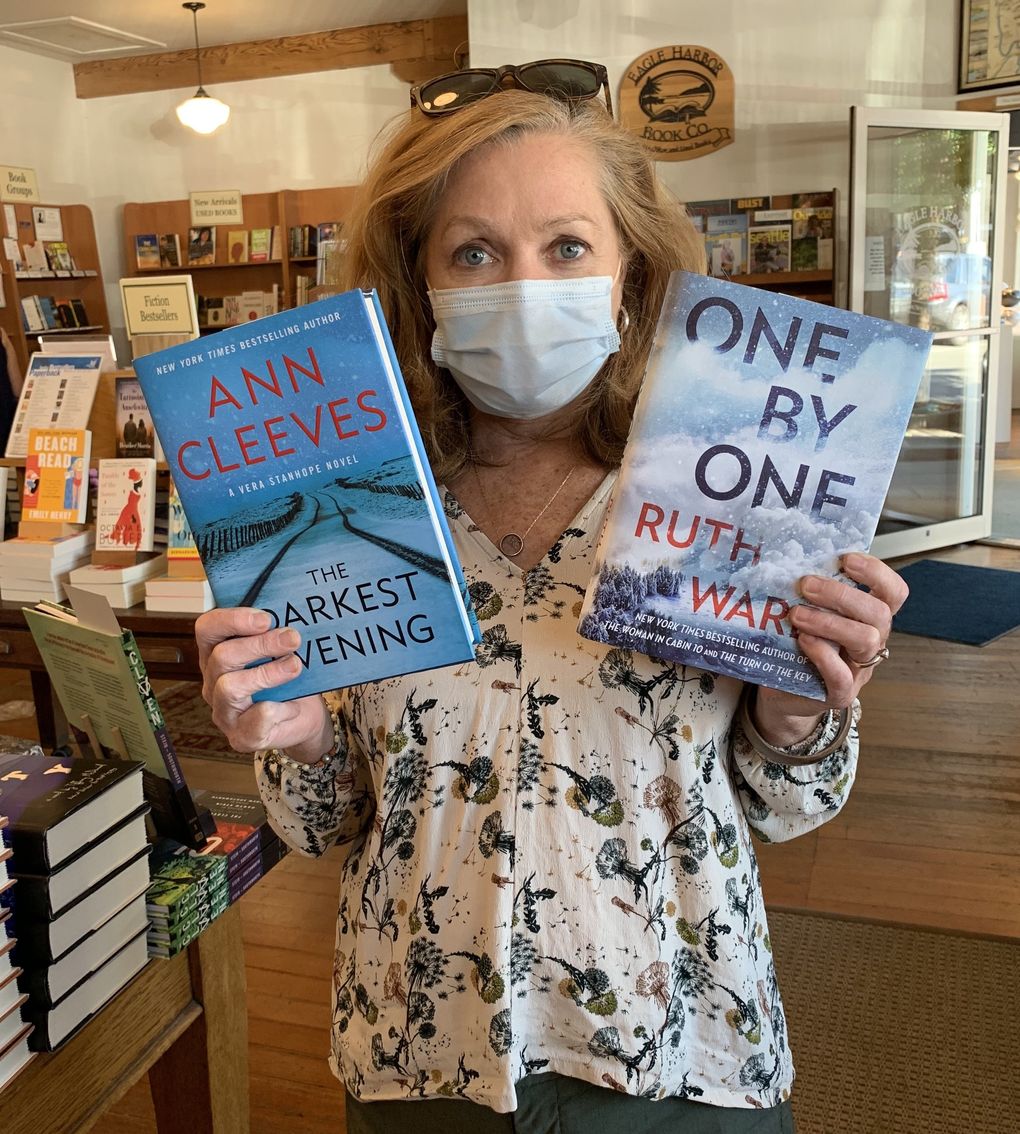 Eagle Harbor Book Company owner Jane Danielson shows off a couple of bestselling titles at her Bainbridge Island bookstore, which also counts among its bestsellers titles from the dense literary talent pool on the island itself. (Courtesy of Eagle Harbor Books)
