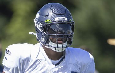 Seattle Seahawks linebacker Jordyn Brooks (56) tosses a signed ball back to  a fan during the NFL football team's training camp, Thursday, Aug. 3, 2023,  in Renton, Wash. (AP Photo/Lindsey Wasson Stock