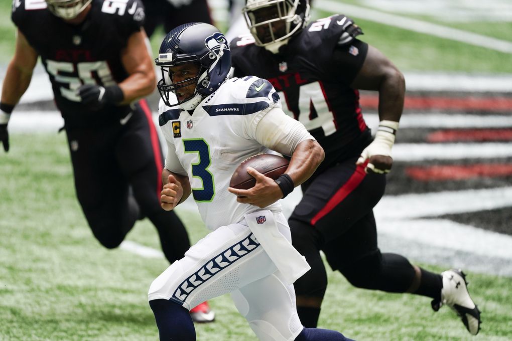 Seahawks quarterback Russell Wilson runs for a first down Sunday against the Falcons in Atlanta. (John Bazemore / The Associated Press)