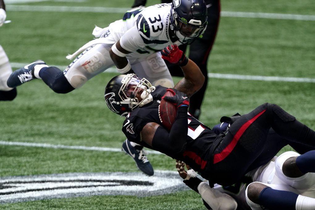 Falcons running back Todd Gurley is stopped by Seahawks strong safety Jamal Adams in the first half Sunday in Atlanta. (John Bazemore / The Associated Press)