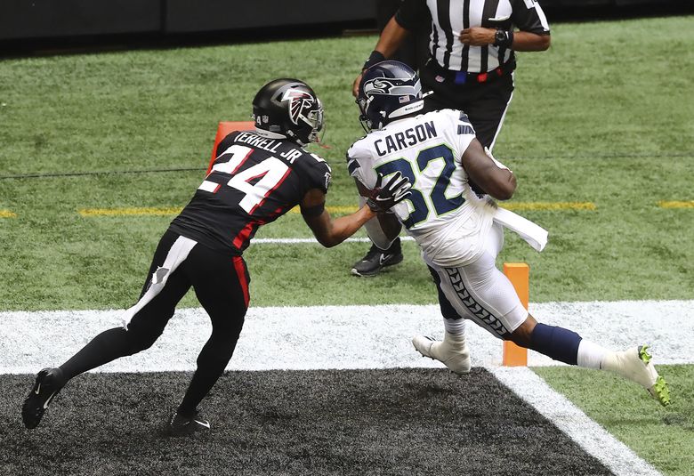 Running back Chris Carson of the Seattle Seahawks carries the ball in