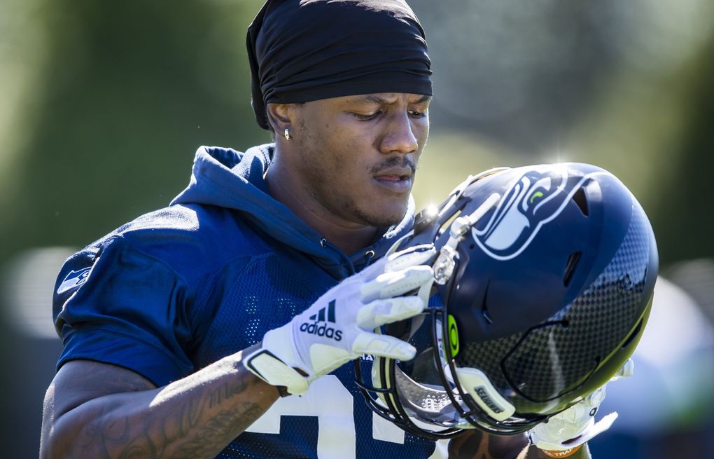 Seahawks running back Chris Carson puts his helmet on at training camp Aug. 28. (Bettina Hansen / The Seattle Times)