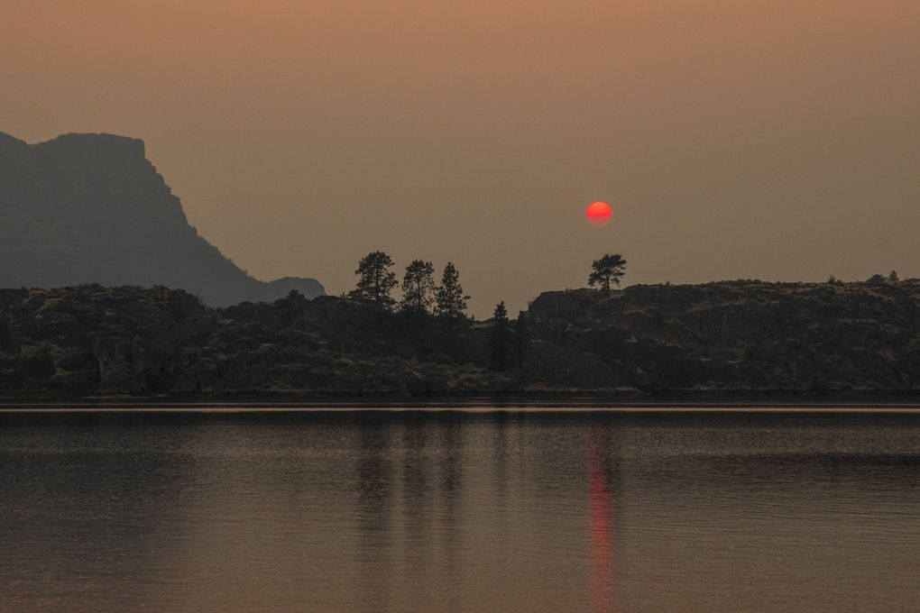 Wildfire smoke covers the horizon as the sun sets over Devils Punch Bowl near Coulee City on Tuesday. (Amanda Snyder / The Seattle Times)