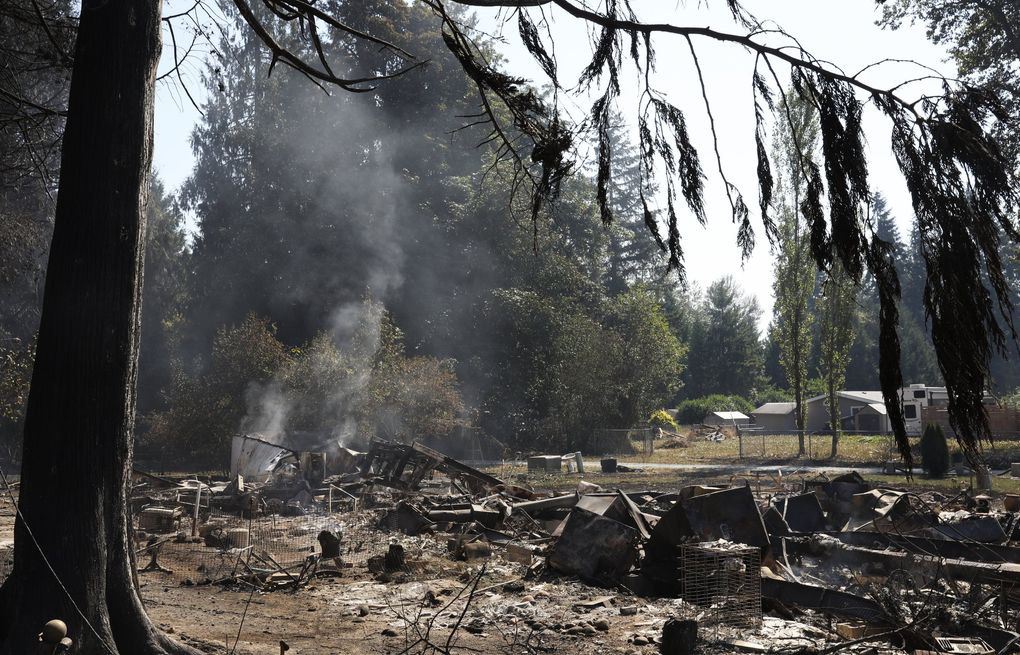 Smoke rises where several homes and vehicles were destroyed in a brushfire Tuesday in Graham. (Ken Lambert / The Seattle Times)