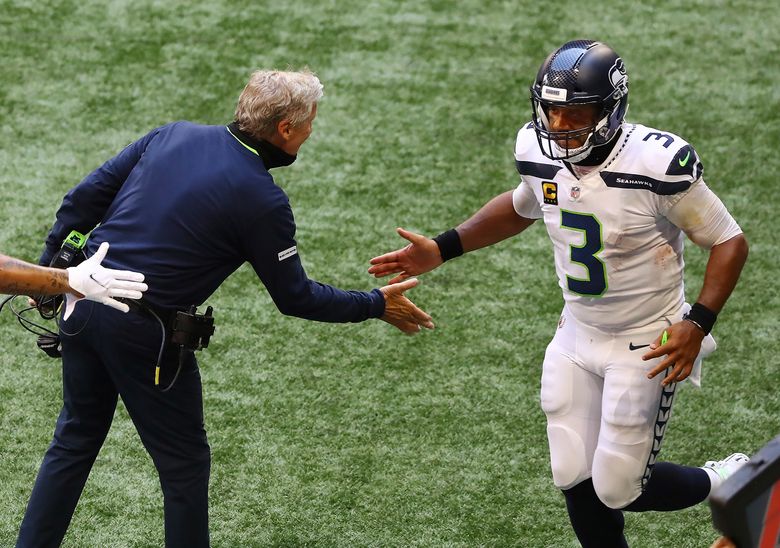 Seattle Seahawks quarterback Russell Wilson gets five from head coach Pete Carroll after tossing a touchdown pass to wide receiver DK Metcalf during an NFL football against the Atlanta Falcons during the third quarter Sunday, Sept. 13, 2020, in Atlanta. (Curtis Compton/Atlanta Journal-Constitution via AP)