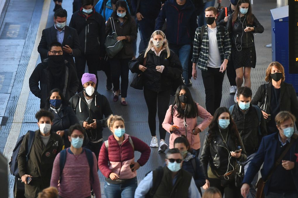 Commuters at Waterloo Station, in London, on Thursday, Sept. 24, 2020. The British government says it may take part in a study that tries to deliberately infect vaccinated volunteers, in an effort to more quickly determine if an experimental COVID-19 vaccine works. (Victoria Jones/PA via AP)