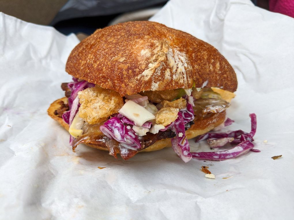 The porchetta sandwich, complete with a vinegar slaw and chicharrones, is a must-have at Heyday Market. (Jackie Varriano / The Seattle Times)